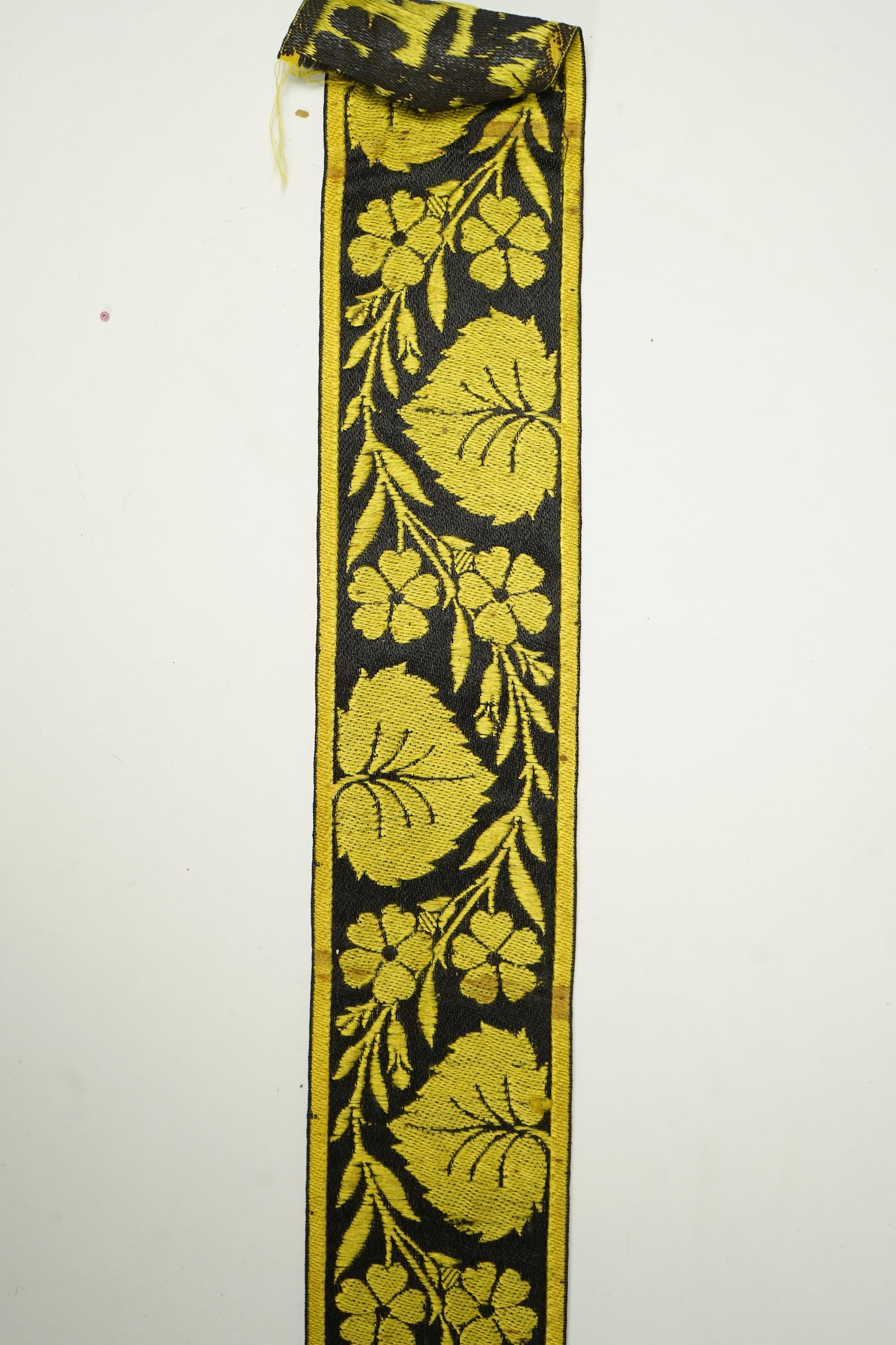 Three long lengths of late 19th century silk woven braiding. One woven in gold, turquoise and maroon silk, possibly for ecclesiastic use, in Christopher Dresser ‘style’ motifs, another in gold and black silk thread in a